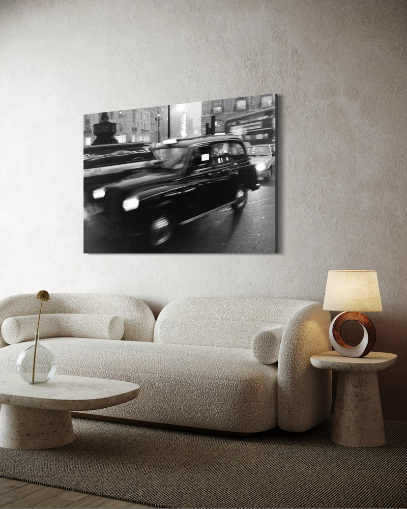 Black-and-white photography on canvas of a taxi in motion through a city environment, with blurred lights and a sense of urban energy.